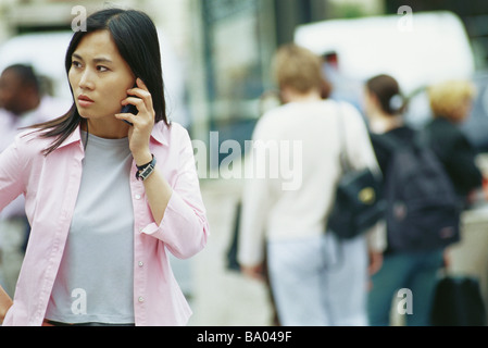 Woman using cell phone outdoors Banque D'Images