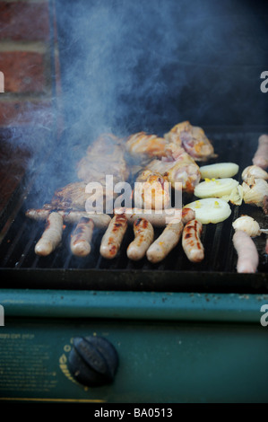 Beefburgers, saucisses, poulet et faire cuire sur un barbecue à gaz Banque D'Images