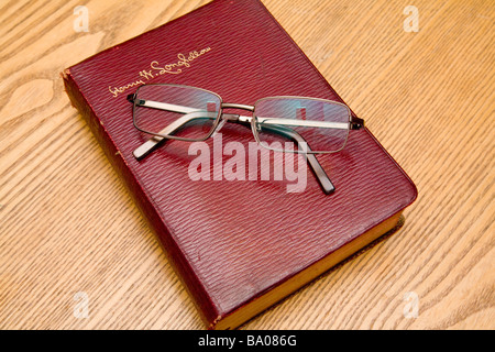 Une paire de lunettes de lecture reposant sur un livre de poèmes de Longfellow.