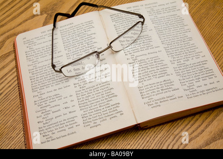 Une paire de lunettes de lecture reposant sur un livre de poèmes de Longfellow.