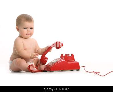 Bébé avec téléphone rouge sur fond blanc Banque D'Images