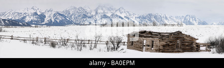 Vaste panorama de la chaîne Teton Mountains dans le Wyoming avec Shane effondré log cabin de film en hiver Banque D'Images