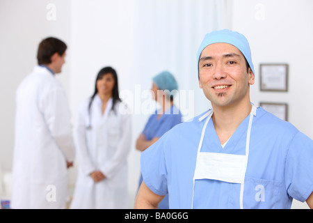 Portrait de chirurgien avec d'autres membres du personnel médical en arrière-plan Banque D'Images