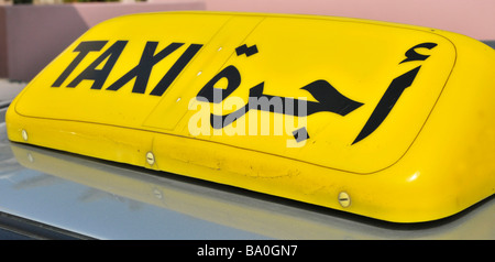 Abu Dhabi gros plan d'un panneau de taxi jaune bilingue monté sur le toit aux Émirats arabes unis, Moyen-Orient, Asie Banque D'Images