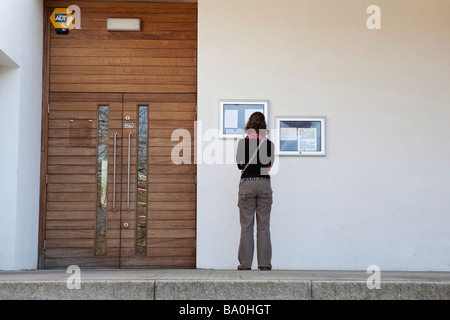 Femme examine l'extérieur d'un menu de restaurant à Jephson Gardens, Leamington Spa, Warwickshire, Angleterre, Royaume-Uni. Banque D'Images