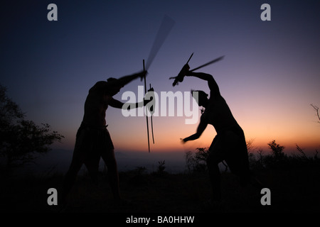 Au Bâton zoulou au coucher du soleil Banque D'Images