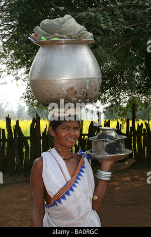 Portrait de femme indienne de la tribu Dhuruba transportant un grand pot d'eau sur la tête. Banque D'Images