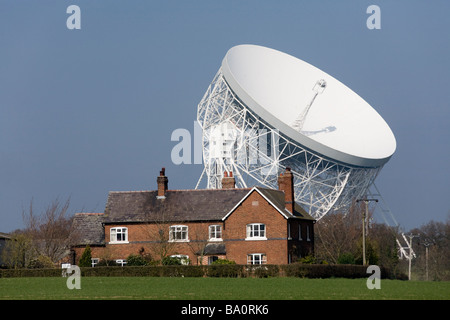 Une maison de ferme et le radiotélescope de Jodrell Bank. Observatoire Jodrell Bank Centre for Astrophysics, près de Goostrey, Knutsford, Cheshire. UK. Banque D'Images