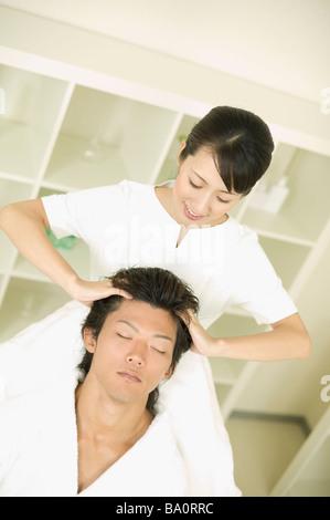Jeune homme recevant un massage de restauration de cheveux Banque D'Images