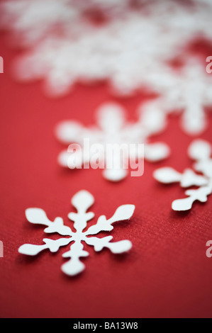 Flocons de neige en papier sur fond rouge Banque D'Images