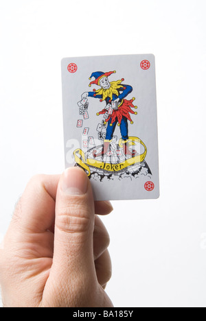 Main tenant joker jeu de carte sur un fond blanc. Banque D'Images