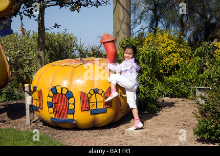 Une jeune fille jouant sur un jouet en forme de citrouille maison pendant des vacances ensoleillées à Skegness Banque D'Images