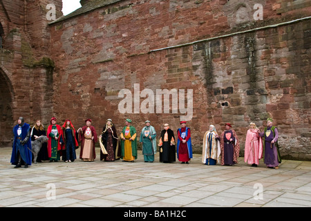 Des paysans vêtus de leurs costumes médiévaux colorées alignées le long du mur au cours de l'abbaye d'Arbroath 1320 re-enactment.UK Banque D'Images