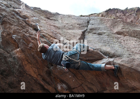L'homme grimpe dans une grotte peu profonde, Eldorado Canyon State Park, Eldorado Springs, Colorado. Banque D'Images