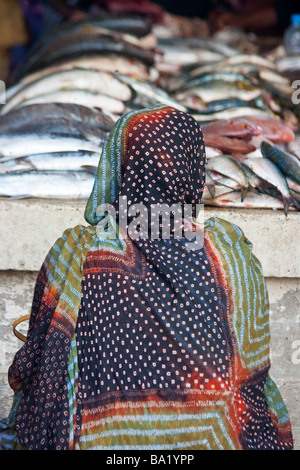 Femme musulmane en face de poisson sur le port de pêche de Nouakchott Mauritanie Banque D'Images