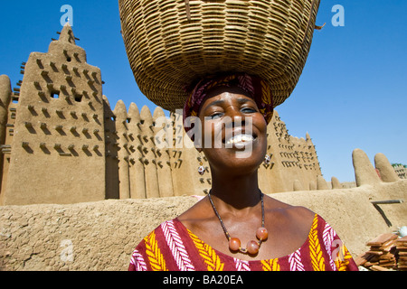 Smiling femme malienne en face de la Grande Mosquée de Djenné au Mali Banque D'Images