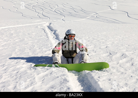 Snowboarder prend un reste en hors-piste, au-dessus de la station de ski Le Fornet, Val D'Isère, Espace Killy, France Banque D'Images