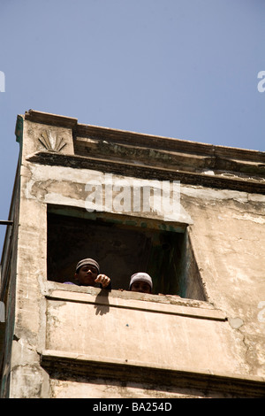 Deux garçons musulmans regarder vers le bas de la véranda d'une madrassa dans la vieille ville d'Ahmedabad, Gujarat. Banque D'Images