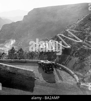 1952, historique, un caméraman de film prend des images du col de Braus, une route sinueuse dans les Alpes, en France, qui fait partie du Rallye Monte-Carlo. Banque D'Images