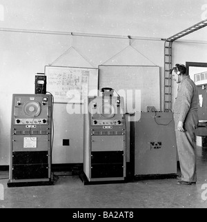 1950s, télécommunications, opérateur masculin avec casque debout par la machinerie de fabriqué par Marconi, un pionnier de la communication sans fil longue distance. Banque D'Images