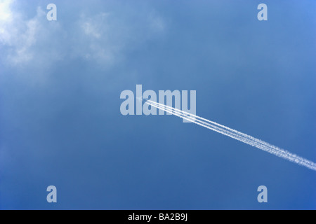 Traînée de condensation blanc à partir d'un avion de ligne Comme il vole à travers un ciel bleu Banque D'Images