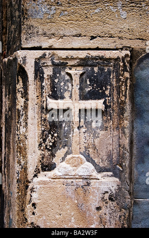 Sculpture en pierre masonique antique d'un crucifix catholique au coin d'un bâtiment à Venise en Italie Banque D'Images