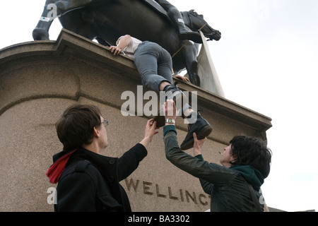 Les jeunes hommes monter sur le socle de la statue de Wellington pendant les manifestations du G20 à la Banque d'Angleterre, Londres UK Banque D'Images