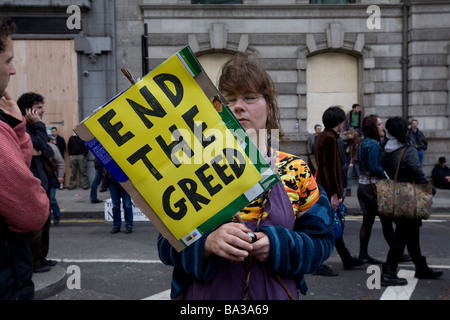 O femme est titulaire d'une plaque à lire 'Fin de la cupidité" au G20 de protester contre la banque d'Angleterre, Londres Banque D'Images