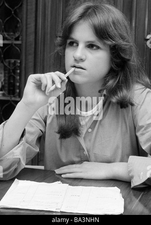 Années 70, photo en noir et blanc, personnage, jeune fille pendant leurs devoirs, réfléchie, de la concentration, un livre d'exercices, un crayon, âgés de 14 à 17 ans, Birgit Banque D'Images