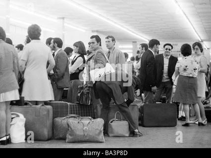 Années 70, photo en noir et blanc, des vacances, du tourisme, de l'aéroport de Düsseldorf, terminal, à l'arrivée, les gens avec une assurance, D-Düsseldorf, Rhin, Rhénanie du Nord-Westphalie Banque D'Images