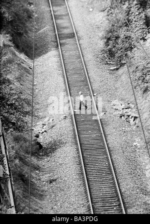 Années 70, photo en noir et blanc, le trafic ferroviaire, le danger, la négligence, le petit garçon traversant une voie ferrée, la vue plongeante, âgés de 8 à 12 ans, D-Oberhausen, D-Oberhausen-Sterkrade, Ruhr, Rhénanie du Nord-Westphalie Banque D'Images