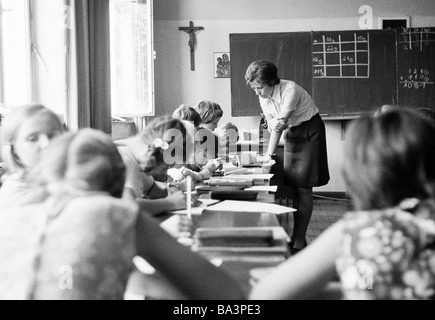 Années 70, photo en noir et blanc, l'édification, l'école, des écoliers et des écolières dans une classe d'école pendant les cours, l'enseignante, les enfants âgés de 7 à 10 ans Banque D'Images