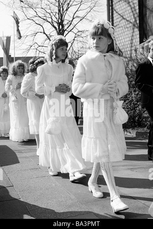 Années 1980, photo en noir et blanc, la religion, le christianisme, la première communion, les filles en robe de communion à pied dans une procession à l'église, âgés de 8 à 12 ans Banque D'Images