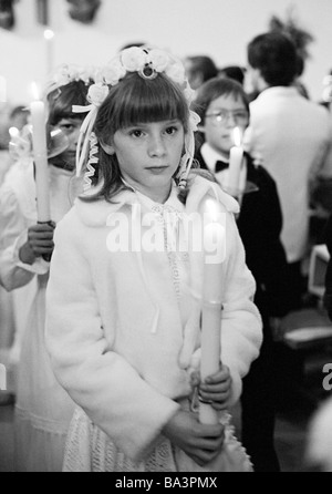 Années 1980, photo en noir et blanc, la religion, le christianisme, la Première Communion, au cours de la procession à l'église les garçons et maintenir la communion des bougies dans la mains, âgés de 8 à 12 ans Banque D'Images