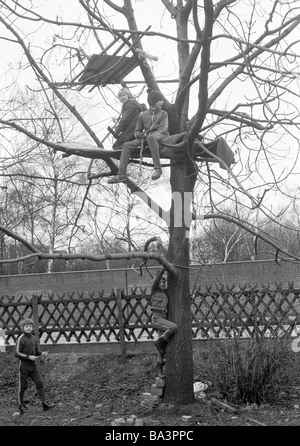 Années 70, photo en noir et blanc, les gens, les enfants, quatre garçons jouant à une maison d'arbre, aire de jeux pour enfants, âgés de 10 à 13 ans Banque D'Images