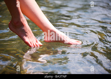 Femme pieds au-dessus de la surface de l'eau close up Banque D'Images