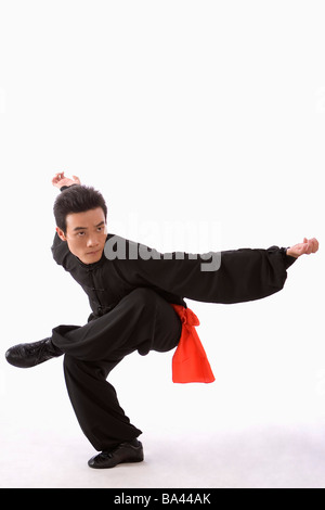 Jeune homme portant l'uniforme d'arts martiaux Kung Fu l'exécution de l'attitude de l'aigle Banque D'Images