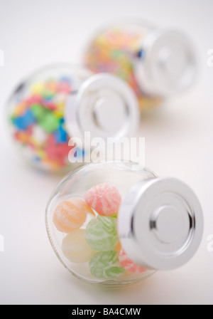Bonbons colorés dans des bocaux en verre dans une rangée Banque D'Images