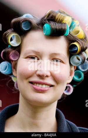 Femme avec des bigoudis dans les cheveux. Banque D'Images