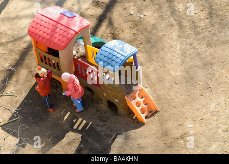 Deux petites filles sur le terrain de jeu pendant la maternelle Première journée ensoleillée après un long hiver Banque D'Images