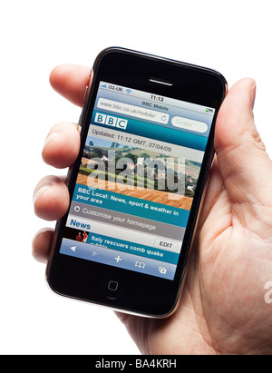 Homme main tenant un iPhone montrant la BBC site Mobile portal Banque D'Images