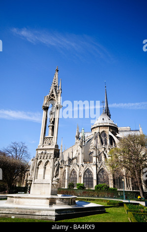 Cathédrale notre-Dame Spire contreforts volants et fontaine avant 2019 incendie Paris France // PARIS, France — la cathédrale notre-Dame, avec sa flèche gothique, ses contreforts volants complexes, et la Fontaine de la Vierge au premier plan, est photographiée avant l'incendie dévastateur de 2019. Cette structure médiévale emblématique, située sur l’Île de la Cité, a historiquement dominé l’horizon parisien. Ses tours jumelles et sa façade détaillée illustrent l'architecture gothique française. Située sur une île de la Seine, la cathédrale est un monument important de la ville et un site classé au patrimoine mondial de l'UNESCO Banque D'Images