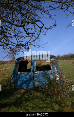 Ancien Bleu rouillé abandonné l'épave d'un vieux mini van dans un champ dans le comté d'Armagh en Irlande du Nord uk Banque D'Images