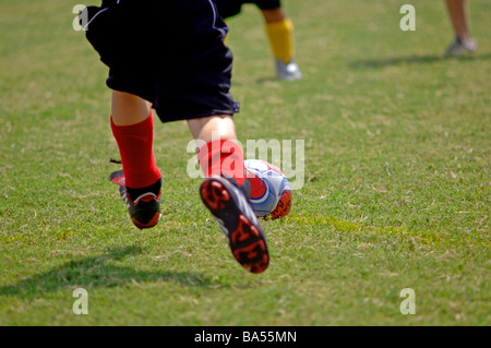 Les jeunes sur un terrain de soccer, course pour le bal Banque D'Images