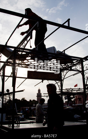Les détenteurs de décrochage construire le métal de leurs stands de nourriture en prévision de la soirée rush, la place Jemaa el Fna, Marrakech Banque D'Images