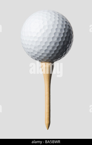 Close-up of white balle de golf sur tee en bois isolés contre fond gris, l'ombre du feu avant gauche supérieur