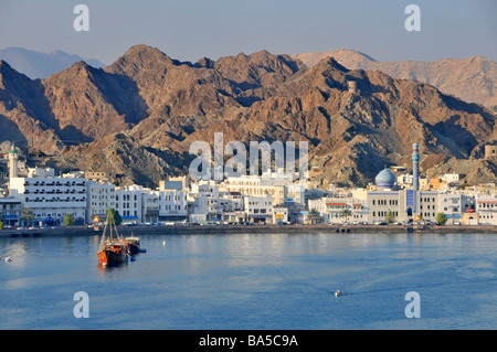 Front de mer et port de Muttrah également orthographié comme Mutrah avec un paysage rocheux aride en toile de fond de Muscat Oman en Asie occidentale Banque D'Images