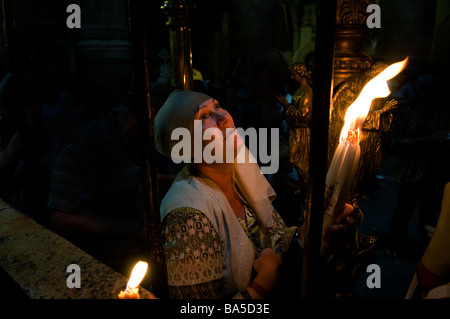 Un chrétien dévot tenir une bougie dans l'église du Saint Sépulcre pendant le Vendredi saint procession Jérusalem Israël Banque D'Images