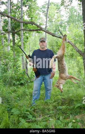 Hunter pose avec coyote Banque D'Images