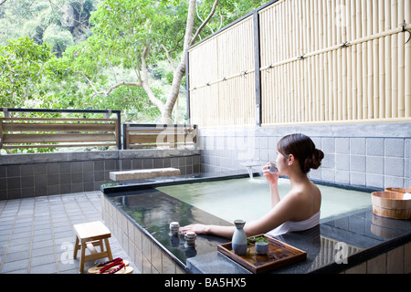 Jeune femme en serviette de bain dans piscine bien potable vue arrière Banque D'Images